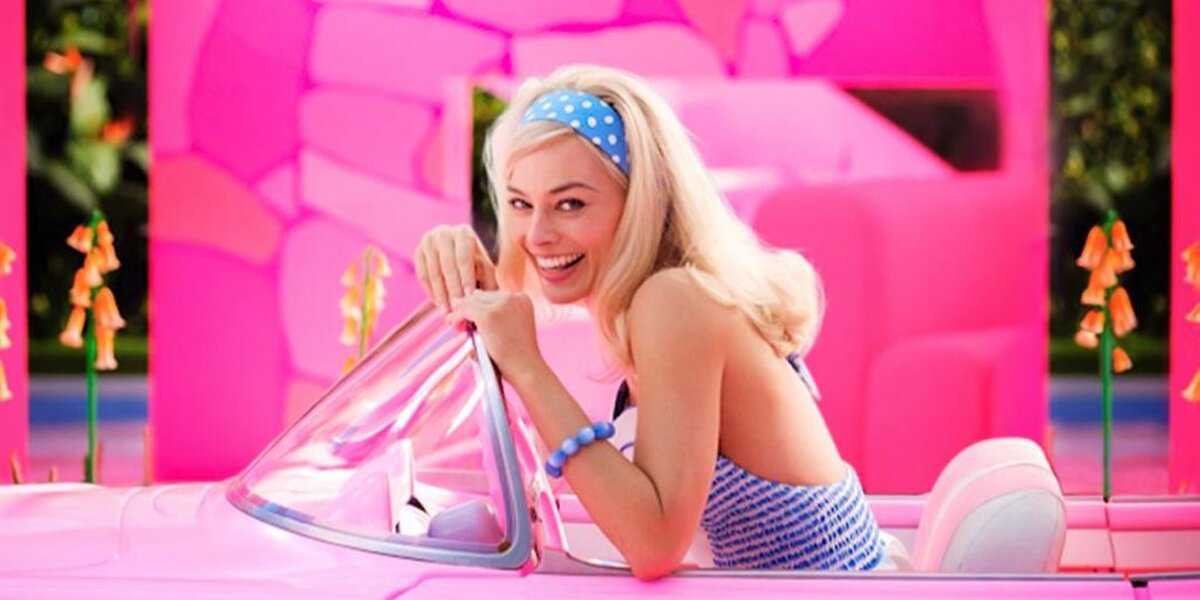 Марго Робби сидит в розовом кабриолете на первом кадре фильма «Барби»